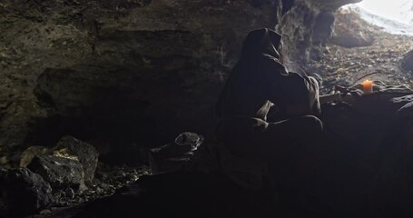 Wall Mural - a medieval monk writes a book in a cave with a candle lit on a cold winter day. a pen with a pen in 