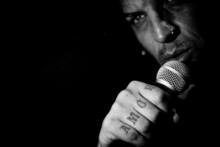 Singer Man With Round Microphone On Dark Background