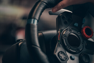 Technology, gaming, entertainment and people concept - young man playing car racing video game at home and steering wheel