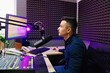 © andrey - a radio host conducts a live broadcast in a professional radio studio.