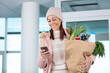 young woman returning home for work with groceries