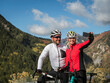 © Tetra Images - United States, Utah, American Fork, Smiling couple with bicycles taking selfie in mountain landscape