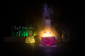 Test glass flask with solution in research laboratory. Science and medical background. Laboratory test tubes on dark toned background , science research equipment concept