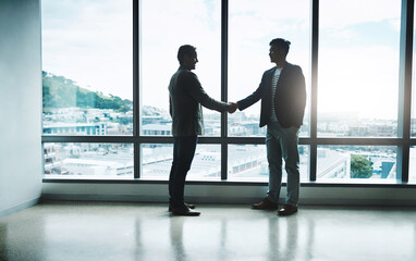 Poster - It all comes down to a handshake. Shot of two confident businessmen shaking hands in agreement while standing inside the office during the day.