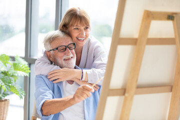 Wall Mural - senior couple looking to painting on a canvas in free time