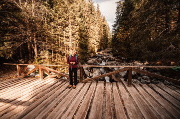  Young traveler hiking girl with backpacks. Hiking in mountains. Sunny landscape. Tourist traveler on background view mockup. High tatras , slovakia