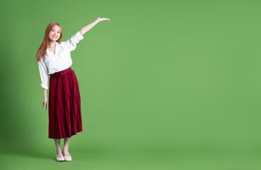 Canvas Print - Beautiful young Asian woman dancing and posing on green background