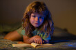 © Volodymyr - Kids reading books. Child reading a book in bed before going to sleep. Child reading a book on bedtime night. Boy reading bedtime story, fairy tale.