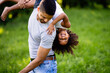 © NDABCREATIVITY - Portrait of happy black father carrying daughter on back outdoors. Family happiness love concept.