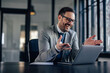 © bnenin - Cheerful caucasian man in a suit, laughing with his coworkers, during a meeting.