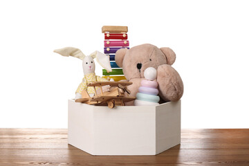 Poster - Set of different toys in box on wooden table against white background