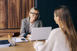 © Ilona - A female professional sitting at a desk in an office is interviewing a candidate for a position.