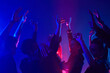 © Seventyfour - Minimal shot of diverse crowd dancing in club with hands up lit by neon lights