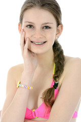 Wall Mural - Portrait of a beautiful teenage girl posing in pink bikini  in studio isolated on white