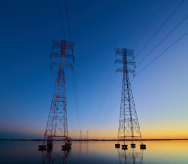 Wall Mural - High voltage transmission lines crossing Wheeler Lake at dusk near Athens AL. Electricity pylons at sunset. Power and energy.