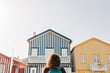 © Eva - back view of backpacker woman in front of colorful houses.promenade of Costa Nova, Aveiro, Portugal
