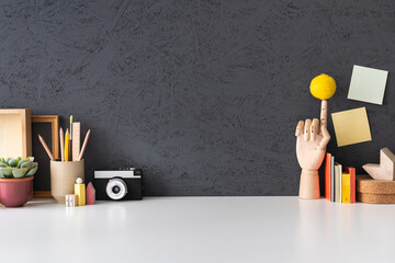 Wall Mural - Creative desk with notebooks, desk objects, office supplies, books, and cactus on a dark blue background..	