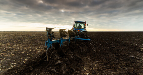 Tractor on the field during sunset.