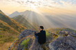 © tampatra - Portrait of Asian man, a tourist or backpacker, travel on green mountain hills with fog on holiday vacation. Nature landscape background, Thailand. People lifestyle.