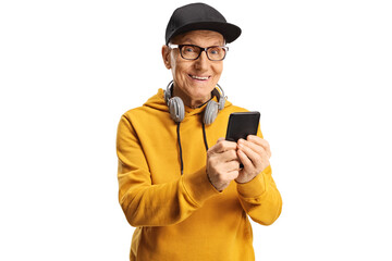 Wall Mural - Elderly man with headphones around neck and a cap holding a smartphone