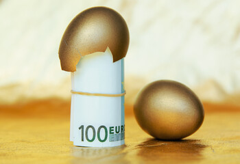 Wall Mural - golden eggs with euro banknotes on gold table, concept of enrichment and wealth	
