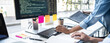 © Freedomz - Writing codes and typing data code technology, Programmer cooperating working on web site project in a software developing on desktop computer at company, Programming with HTML, PHP and javascript