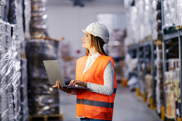 A female supervisor using laptop for adding orders for shipping oversea.