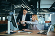 © Liubomir - Two Asian male and female colleagues in a modern office, a woman shows the work done on the monitor, consults and discusses