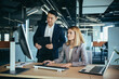 © Liubomir - Two Asian male and female colleagues in a modern office, a woman shows the work done on the monitor, consults and discusses