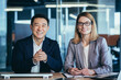 © Liubomir - a team of business employees at an online meeting look at camera and communicate. Webcam view. conference remote interview. Two office workers talking Video call conversation. Asian male and female