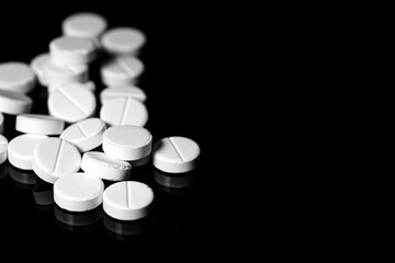 Close up of white painkiller tablet on a reflective black background