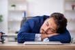 © Elnur - Young male employee extremely tired in the office