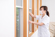 © buritora - 窓を開けて換気をする看護師