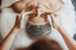 Beautician's hands applying facial cleansing foam on woman's face massaging skin in spa salon. Beauty face. Cosmetology beauty procedure. Beauty skin care.