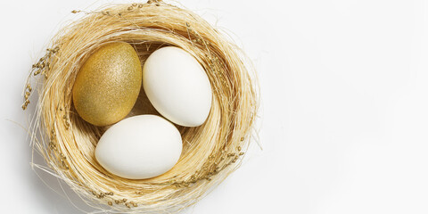 Wall Mural - Easter Golden eggs in straw nest on white background. Trendy gold egg for spring holiday. Top view sparkle Easter minimal creative composition. Happy Easter spring holiday