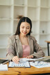 © PaeGAG - Business woman using calculator for do math finance on wooden desk in office and business working background, tax, accounting, statistics and analytic research concept