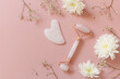 © elena_hramowa - Rose quartz facial massage roller over pink background with gypsophila flowers. Massage tools with jade stone, anti-aging, anti-wrinkle beauty skincare tool. Top view flat lay. Copy space.