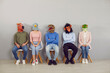 © Studio Romantic - People in funny extravagant masquerade masks waiting for job interview. Group of male and female applicants wearing inappropriate wacky comedy fancy dress animal masks sitting on chairs by office wall