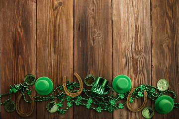 Wall Mural - St Patricks Day border of shamrocks beads and coins over a rustic wood background