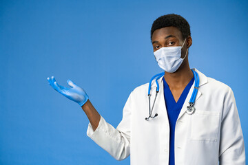 Wall Mural - Confident black doctor in face mask and gloves in blue studio