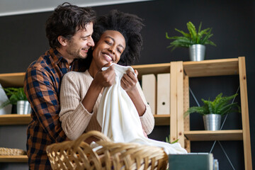 Young couple at home doing hosehold chores and ironing together