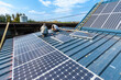 © S. Leitenberger - Energie renouvelable. Pose de panneaux photovoltaiques sur le toit d'un batiment agricole ancien