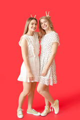 Poster - Portrait of happy young sisters on color background