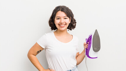 Wall Mural - pretty hispanic girl smiling happily with a hand on hip and confident. laundry concept