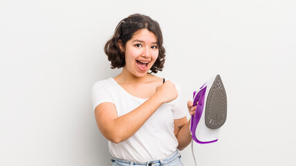 Wall Mural - pretty hispanic girl feeling happy and facing a challenge or celebrating. laundry concept