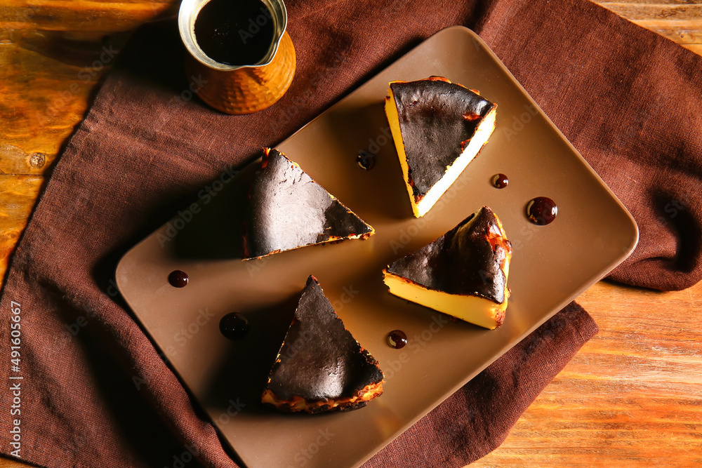 Plate with slices of tasty Basque burnt cheesecake on table
