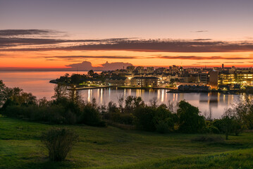 Wall Mural - View of a city on a lake at Dusk. Reflection in water. Kingston, ON, Canada.