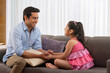 © IndiaPix - Father and daughter playing together while sitting on sofa at home