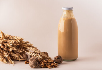 glass bottle with milk and walnuts on the table.