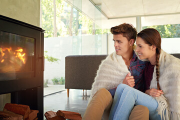 Canvas Print - Cuddling by the fireplace. Shot of an affectionate couple sitting by the fireplace in their living room.